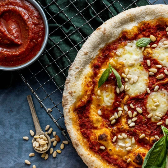 Italiensk pizza med tomatsaus og pinjekjerner